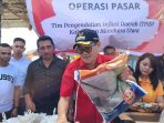 Bupati Minahasa Utara Joune Ganda saat melayani masyarakat di Pasar murah yang dilaksanakan di Pasar Kauditan.